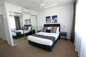a hotel room with a large bed and a mirror at Q Resorts Paddington in Townsville +43 photos
