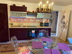 een keuken met een glazen tafel en een fornuis top oven bij Pension Hadanig in Techelsberg am Worthersee