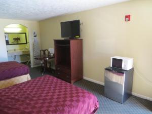 ein Hotelzimmer mit 2 Betten und einem Flachbild-TV in der Unterkunft Americas Best Value Inn & Suites Hempstead in Hempstead