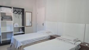 a room with two beds and a mirror at APARTAMENTOS NO CENTRO DE BRASILIA. in Brasilia