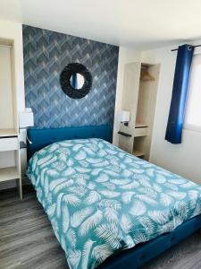 - une chambre avec un lit bleu et un miroir dans l'établissement Studio 5 charmant tout équipé à la gare de Lorient, à Lorient