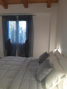 a bedroom with a large bed with a window at B&b nonna dedda in Oristano