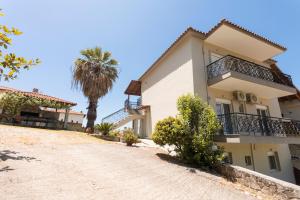 a house with a palm tree and a dirt road at FOTINI'S HOUSE in Nea Skioni