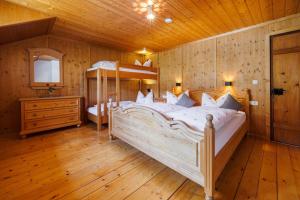 a bedroom with a large bed and a wooden ceiling at Steinberger Hof Alm inkl. Chiemgau Karte in Ruhpolding