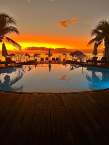 a swimming pool with a sunset in the background at Troux aux Biches Le Cerisier A2 Mauritius in Trou aux Biches