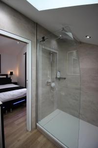 a glass shower in a bathroom with a bedroom at Le grain de Louise in Lancié