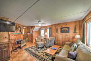 a living room with a couch and a table at Sebago Lake Cottage with Patio and Beach Access! in North Sebago