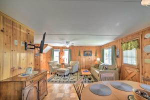 a living room with wood paneling and a table in a room at Sebago Lake Cottage with Patio and Beach Access! in North Sebago