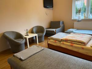 Pokój z łóżkiem, 2 krzesłami i stołem w obiekcie Pod Lipami w mieście Kołczygłowy