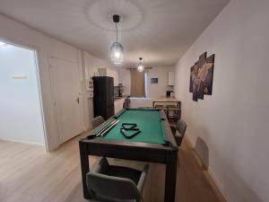 een tafeltennistafel in een woonkamer met een tafel bij Privée : Jacuzzi + sauna + billard + jeux SO in Saint-Quentin