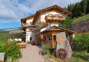 a large wooden house with a balcony on a mountain at Gasthaus Bad Siess in Longomoso