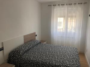 a bedroom with a bed and a window at ApartamentoValleTena9 in Sabiñánigo