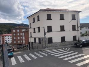 a white building with a crosswalk in a parking lot at ApartamentoValleTena9 in Sabiñánigo