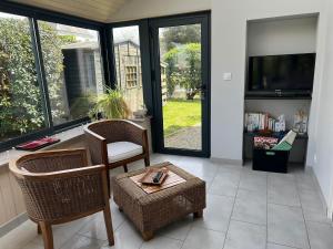 a living room with two chairs and a television at Kêr Korrigan - Villa familiale in Saint-Gildas-de-Rhuys