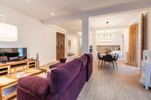 a living room with a purple couch and a dining room at Lujo, comodidad y espacio Gijon centro in Gijón