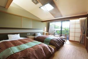a bedroom with two beds and a large window at Hotel Fuki no Mori in Nagiso +30 photos