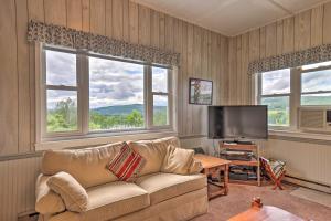 a living room with a couch and a flat screen tv at Apartment with Shared Deck and View of Cowanesque Lake in Lawrenceville