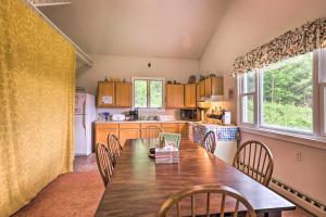 a kitchen with a table and chairs and a kitchen with a refrigerator at Apartment with Shared Deck and View of Cowanesque Lake in Lawrenceville