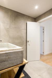 een badkamer met een bad en een glazen deur bij Lujo, comodidad y espacio Gijon centro in Gijón