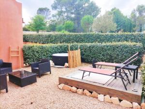 a patio with a table and a bench and a tub at Quiétude en Luberon in Roussillon
