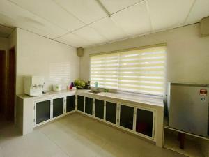 a kitchen with a sink and a window with blinds at Pak Long Shoplot Homestay 2 in Shah Alam