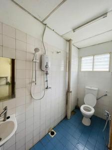 uma casa de banho com um WC e um chuveiro. em Pak Long Shoplot Homestay 2 em Shah Alam