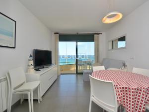 een woonkamer met een eettafel en een televisie bij Super Beach 3B in Platja  d'Aro