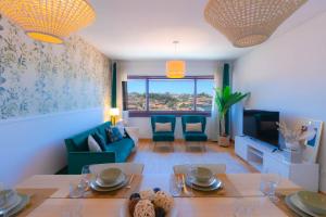 a living room with a table and a couch and a tv at 180º Porto River View in Vila Nova de Gaia