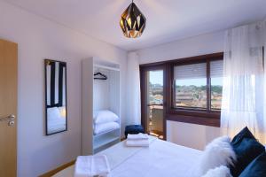 a bedroom with a large bed and a window at 180º Porto River View in Vila Nova de Gaia