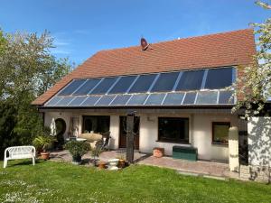 Ein Haus mit einem Haufen Sonnenkollektoren darauf in der Unterkunft Ferienwohnung Erfurt Marbacher Höhe in Erfurt