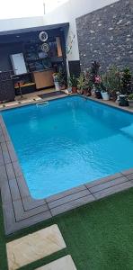 a large blue swimming pool with green grass at YOUR HOME AWAY FROM HOME in Praia