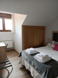 a bedroom with a bed with two towels on it at Los Casares in Riaño