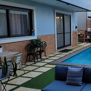 a patio with a pool and a table and chairs at YOUR HOME AWAY FROM HOME in Praia