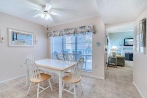 a dining room with a table and chairs and a window at Madeira Beach Yacht Club 215F, 2 Bedrooms, Pool Access, Spa, WiFi, Sleeps 6 in St Pete Beach
