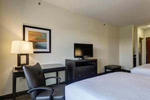 um quarto de hotel com duas camas e uma secretária e uma televisão em Holiday Inn Express and Suites Sikeston, an IHG Hotel em Sikeston