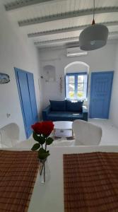 a living room with a blue couch and a flower in a vase at BAROS VIEW in Apérathos