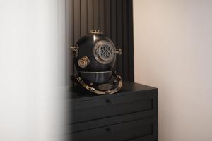 un casco negro sentado en la parte superior de un tocador en Bheaven I Explorer Premium Apartment, en Bremerhaven