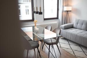 sala de estar con mesa de cristal y sillas en Bheaven I Explorer Premium Apartment, en Bremerhaven