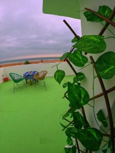 stół i krzesła na dachu budynku w obiekcie Thayri Hostel w mieście Sidi Kaouki