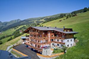 duży drewniany dom na szczycie wzgórza w obiekcie Mei.Berg premium view Appartements w Saalbach Hinterglemm