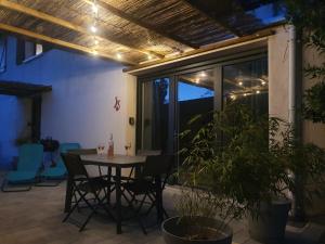 patio con mesa, sillas y ventana en LA PIERRINA - Chamois - Appart 3 étoiles, en Aix-les-Bains
