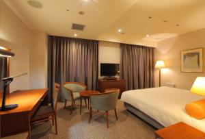 厚木市にある小田急ステーションホテル本厚木のベッドとデスクが備わるホテルルームです。