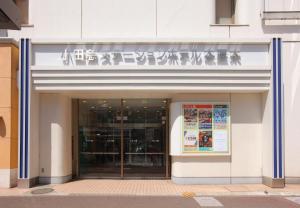 un edificio con un cartel en la parte delantera en Odakyu Station Hotel Hon-Atsugi en Atsugi