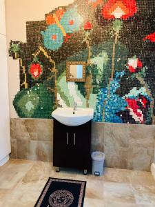 a bathroom with a sink and a mosaic wall at Durban Italian villa 1&2 in Durban