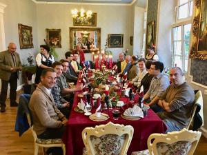 um grupo de pessoas sentadas à volta de uma mesa numa sala em Jagdschloss lalendorf em Lalendorf