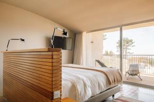 a bedroom with a bed and a balcony at Immerso Hotel, a Member of Design Hotels in Ericeira