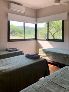 a room with three beds and a large window at Casa de campo in Villa San Nicolás