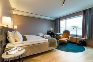 una camera d'albergo con un letto grande e una scrivania di Scandic Linköping City a Linköping