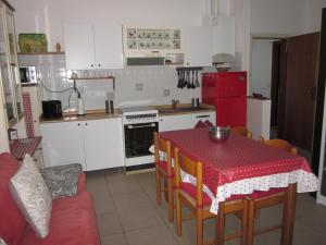 a kitchen with a table with a red table cloth on it at Appartamento Lido di Dante in Lido di Dante