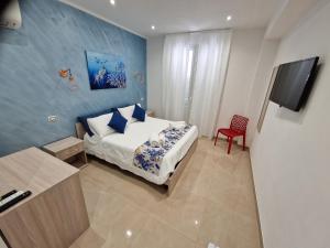 1 dormitorio con 1 cama y TV de pantalla plana en Corallo Rosso B&B en Terrasini Favarotta